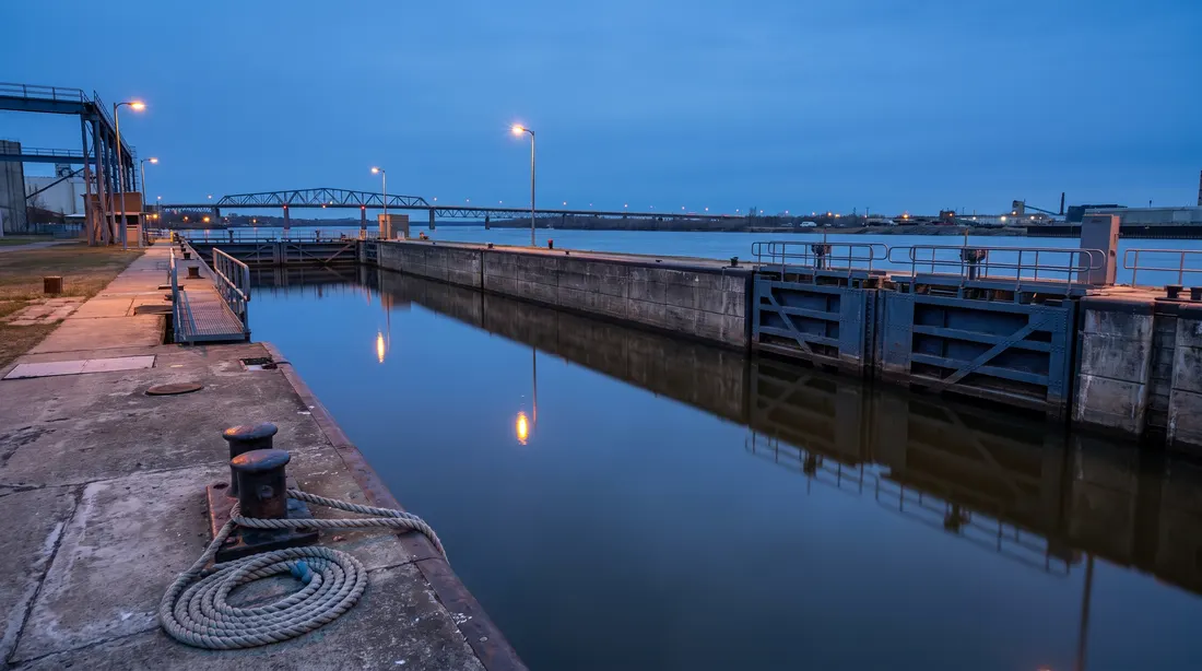 Canal lock with closed steel gates at blue hour